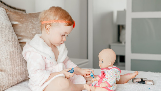 baby-playing-with-baby-doll