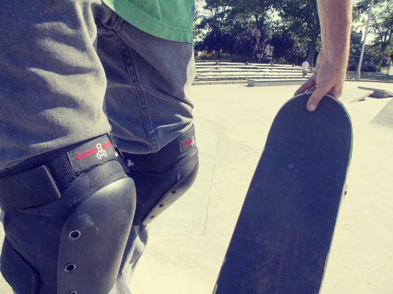 man wearing skateboarding sleeve pads and holding his skateboard