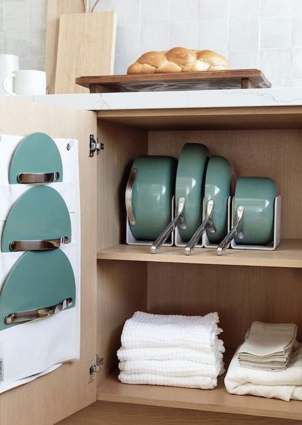 green pots and pans stored in a kitchen drawer