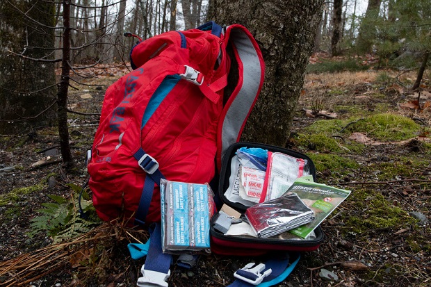 red hiking backpack and first aid kit