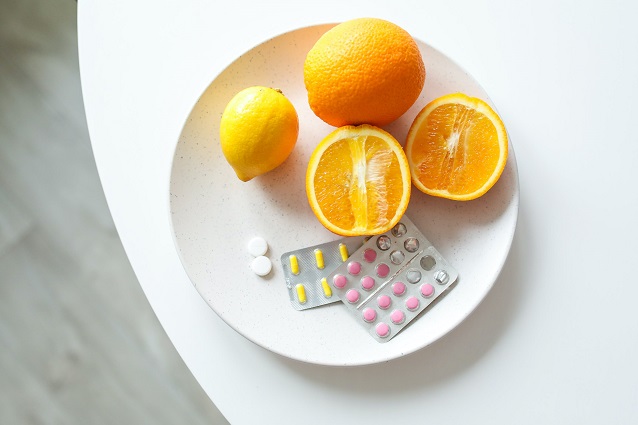 picture of oranges, lemon and vitamins c in a plate on a table