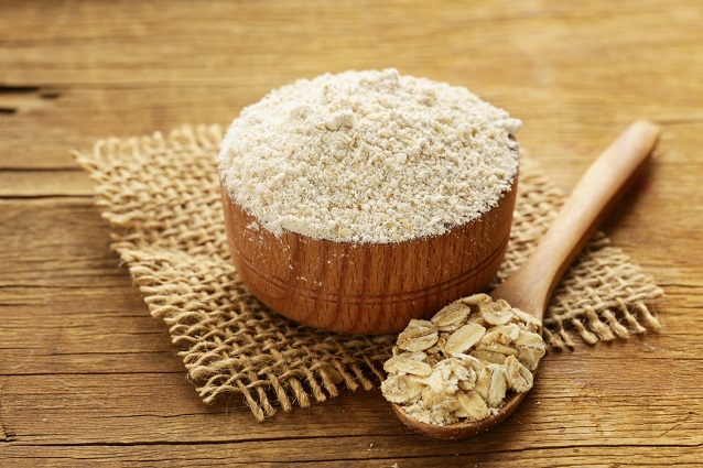 oat gluten free flour in wooden bowl  and oats in a spoon 