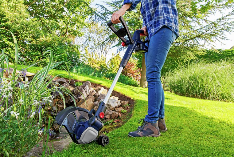 Man working with grass trimmer that has wheels
