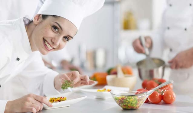 a chef covering her hair in the kitchen 