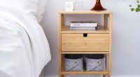 Wooden bedside table with lamp and details on it