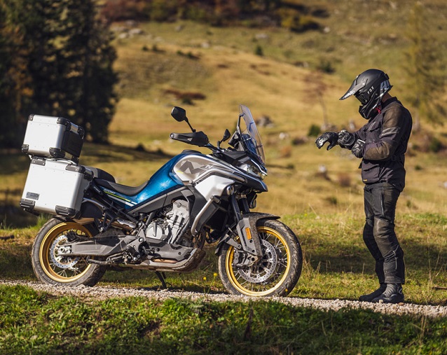 Motorcycle parked in nature and rider standing by the motorcycle