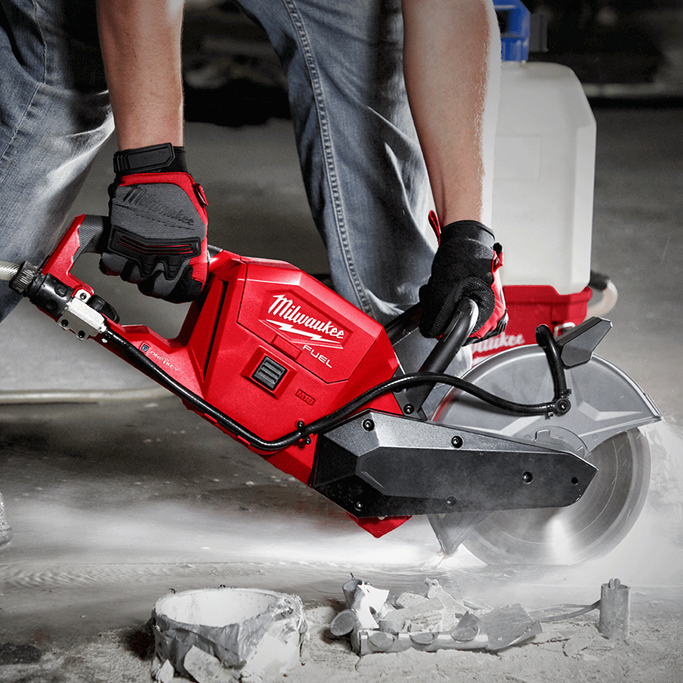 A person using a concrete cutting saw to cut through concrete