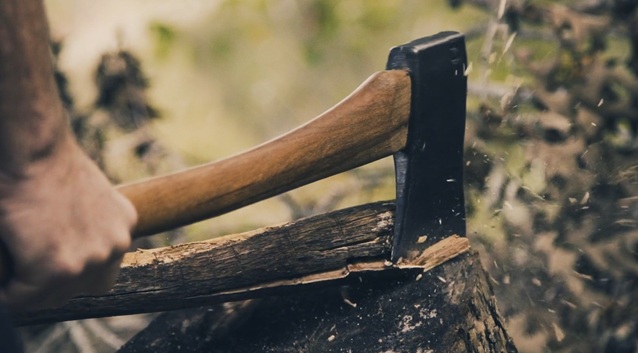 man using survival axe